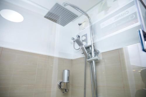 a shower with a shower head in a bathroom at Shore2 Luxurious & Homely Suite near MOA in Manila