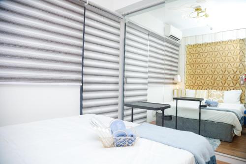 a bedroom with two beds and a large window at Shore2 Luxurious & Homely Suite near MOA in Manila