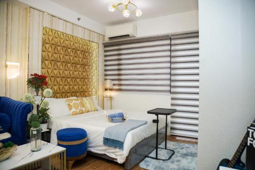 a hotel room with a bed and a chair at Shore2 Luxurious & Homely Suite near MOA in Manila