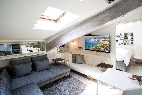 un salon avec un canapé et une télévision dans l'établissement 2 room CannesVacationRental by AmericanVacationLiving, à Cannes