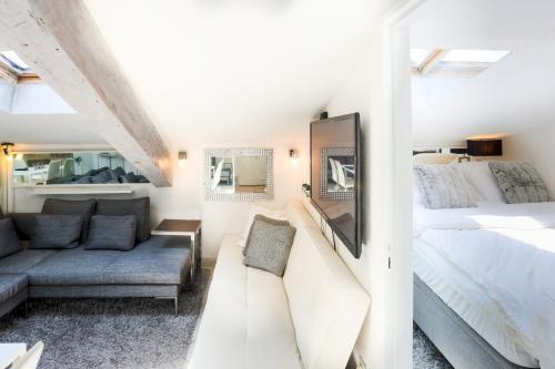 Habitación blanca con cama y sofá en 2 room CannesVacationRental by AmericanVacationLiving, en Cannes