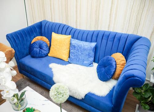 a blue couch with pillows on it in a living room at Shore2 Luxurious & Homely Suite near MOA in Manila