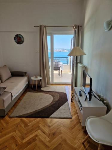 a living room with a couch and a view of the ocean at Apartments Panorama 2 in Trogir