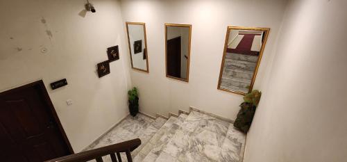 a hallway with paintings and pictures on the walls at Red Fort Hotel Gulberg in Lahore