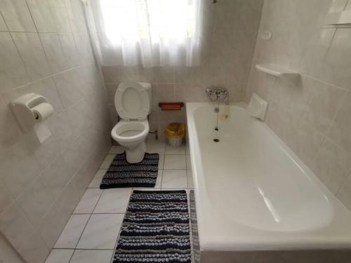 a bathroom with a bath tub and a toilet at Tugela Mouth Sea View Guest House (Sleeps 8) in Tugela Mouth