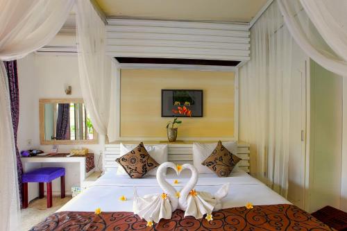 a bedroom with a bed with two white hearts on it at Private Pool Villas Kuta Bali in Kuta