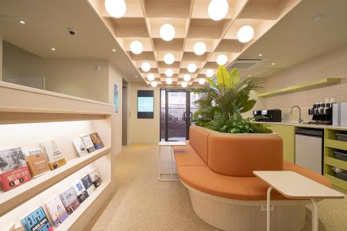 an office with a bench and a plant in the middle at Workers Hotel Ansan by AANK in Ansan