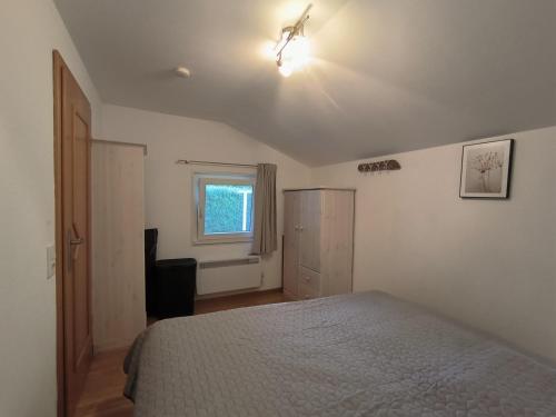 ein weißes Schlafzimmer mit einem Bett und einem Fenster in der Unterkunft Ferienhaus Paulsen in Silberstedt