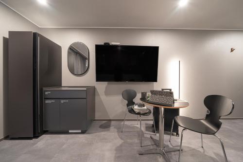 a room with a table and chairs and a television at Workers Hotel Ansan by Aank in Ansan