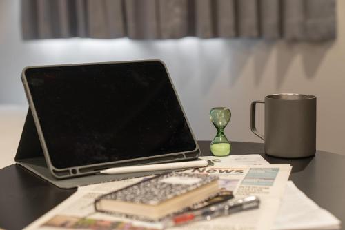 a laptop computer sitting on top of a desk with a keyboard at Workers Hotel Ansan by Aank in Ansan