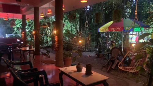 a restaurant with a table and chairs and an umbrella at Jungleview Home Stay in Idukki