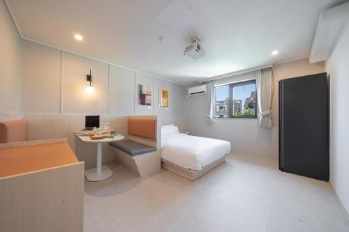 a bedroom with a bed and a desk and a table at Workers Hotel Ansan by Aank in Ansan