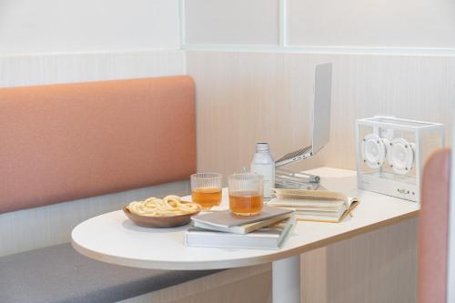 a table with two glasses of beer and a microwave at Workers Hotel Ansan by Aank in Ansan