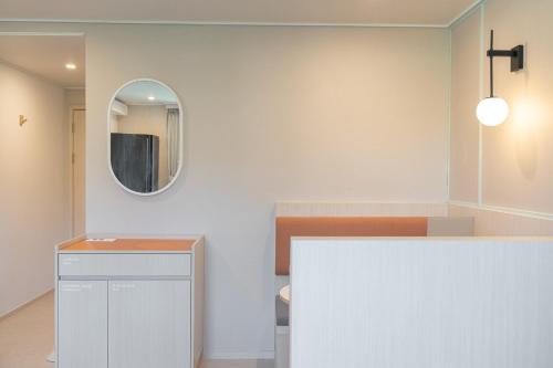 a bathroom with a mirror and a white counter at Workers Hotel Ansan by Aank in Ansan