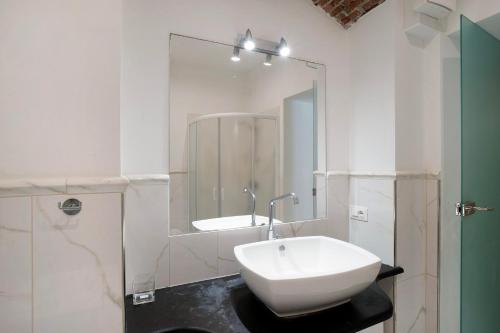 a white bathroom with a sink and a mirror at La credenza, borgo dei pescatori in Cervo