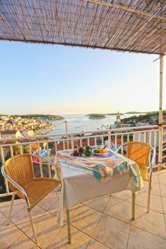 a table and chairs on a balcony with a view of the ocean at Apartments Boćin Rosso in Hvar