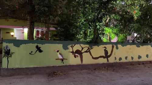 a wall with birds painted on the side of it at Jungleview Home Stay in Idukki