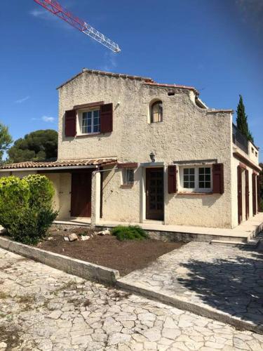 une vieille maison avec une grue au sommet dans l'établissement Charmante Maison proche d une calanque, à Sausset-les-Pins
