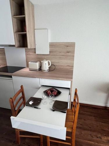 - une table blanche avec deux chaises et une table avec une bouilloire dans l'établissement Studio rénové dans Saint-Lary, à Saint-Lary-Soulan
