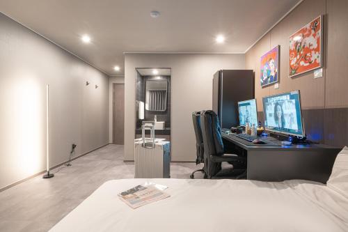 a room with a desk with a computer and a bed at Workers Hotel Ansan by Aank in Ansan