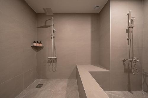 a bathroom with a shower with a glass door at Workers Hotel Ansan by Aank in Ansan