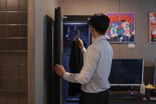 a man is standing in front of a refrigerator at Workers Hotel Ansan by Aank in Ansan