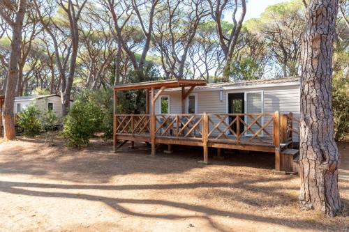 a house with a wooden porch in the woods at Gitavillage Le Marze in Marina di Grosseto