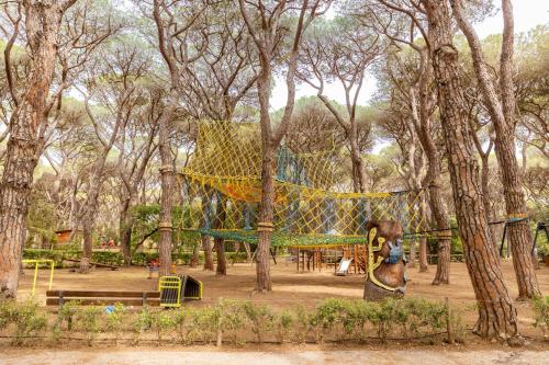a playground in a park with a yellow net at Gitavillage Le Marze in Marina di Grosseto
