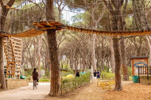 a person riding a bike in a park with trees at Gitavillage Le Marze in Marina di Grosseto