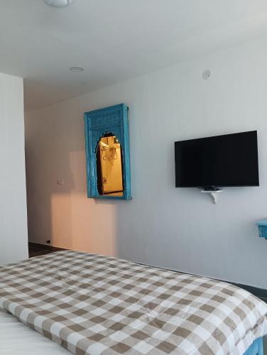 a bedroom with a bed and a tv on the wall at Hotel Mewari Villa PURE VEG in Udaipur