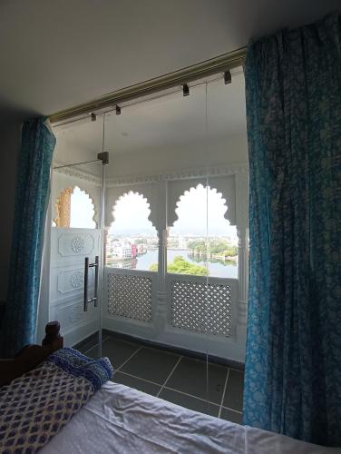 a bedroom with a bed and a window with a view at Hotel Mewari Villa PURE VEG in Udaipur