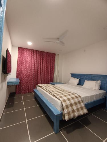 a bedroom with a bed and a red curtain at Hotel Mewari Villa PURE VEG in Udaipur