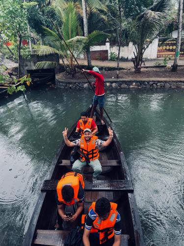 a group of people in a boat in the water at Vrindavan homestay in Munroe Island