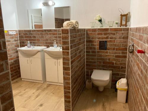 a bathroom with two sinks and a brick wall at Chalupa u Brčáků in Ktiš