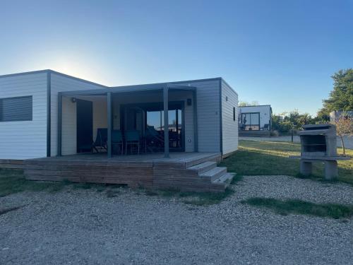 a tiny house with a porch and a stove at Paradis De Bellevue in Puymiclan