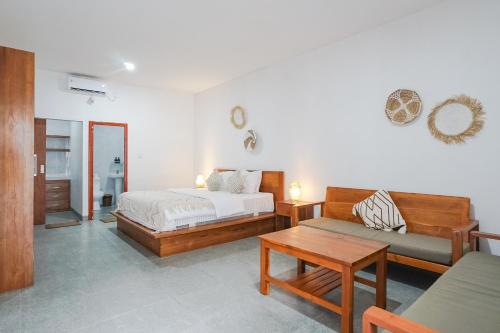 1 dormitorio con cama, sofá y mesa en Maisaba Coliving Cempaka en Dalung
