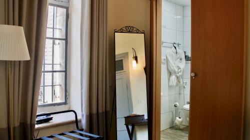 een badkamer met een spiegel, een toilet en een raam bij Farah Locanda in Ramallah