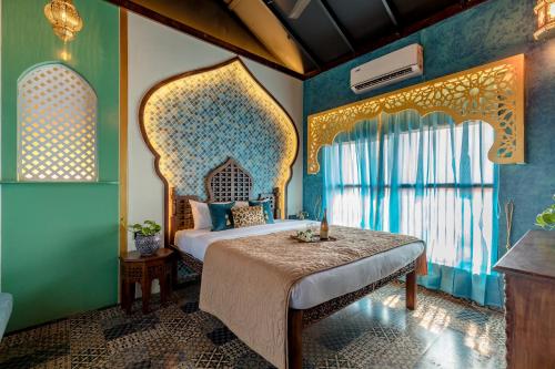 a bedroom with a bed in a room with blue walls at Dio Regaalo Theme Resort, Ratnagiri in Ratnagiri