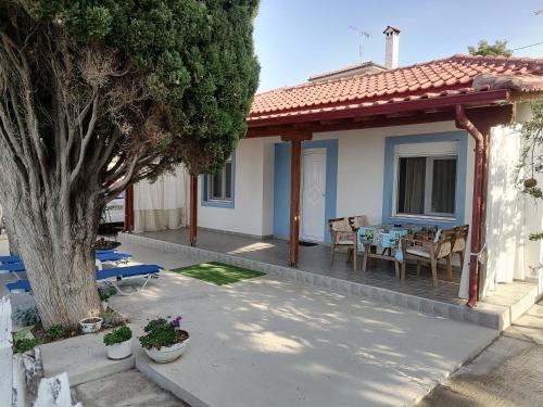a house with a porch with a table and chairs at Porto Almira Beachfront House in Nikiti