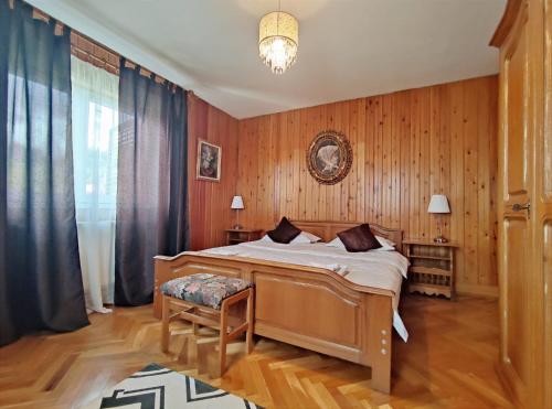 1 dormitorio con 1 cama con paredes de madera y suelo de madera en Lelia Residence Apartments, en Brasov