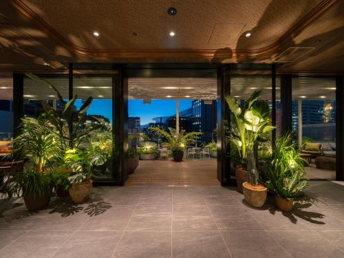 a lobby with potted plants in a building at GINZA HOTEL by GRANBELL in Tokyo