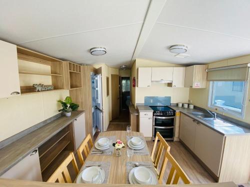 a kitchen with a table with plates on it at New Forest Bees Holiday Home, Bashley in New Milton