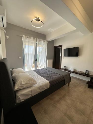 sypialnia z łóżkiem i telewizorem z płaskim ekranem w obiekcie Elegant Escapes 4 w Atenach
