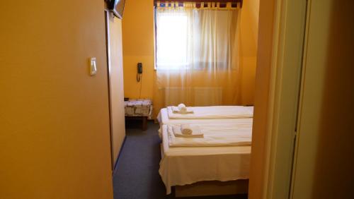 a room with two beds and a window at Attila Hotel Budapest in Budapest