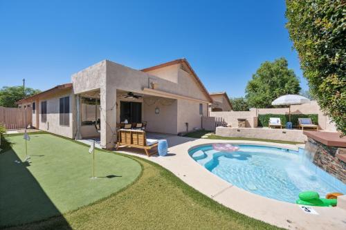 a backyard with a swimming pool and a house at Chic Desert Retreat - Lush Spa Pool - Mini Golf in Phoenix