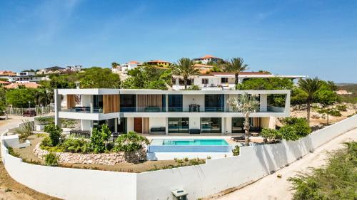 une maison sur la plage avec une piscine dans l'établissement Luxury 12-Person Villa in Cas Abou with Pool, Seaview, and Private Beach Access, à Willibrordus