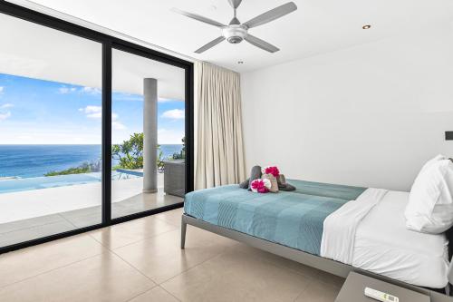 a bedroom with a bed with two teddy bears on it at Luxury 12-Guest Villa in Gated Community with Pool, Ocean View & Private Beach Access in Willibrordus