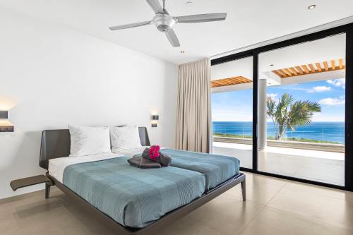 a bedroom with a bed with a view of the ocean at Luxury 12-Guest Villa in Gated Community with Pool, Ocean View & Private Beach Access in Willibrordus