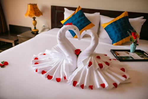 two swansrendered to look like they are kissing on a bed at La Charm Hoi An Hotel & Spa in Hoi An