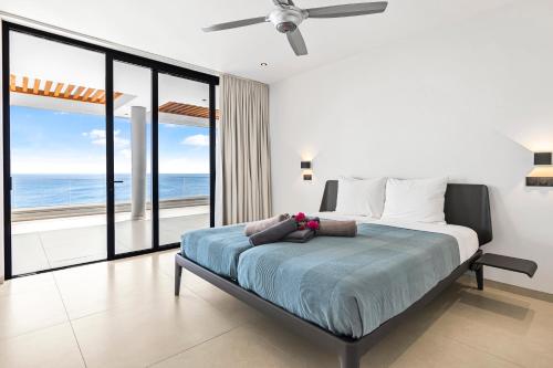 a bedroom with a bed with a view of the ocean at Luxury 12-Guest Villa in Gated Community with Pool, Ocean View & Private Beach Access in Willibrordus